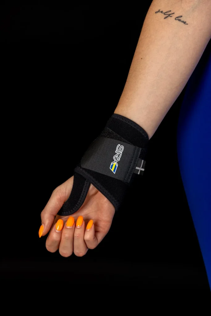 Bandáž zápästia s fixáciou palca Mediroyal SRX na ruke modelky, čierne pozadie