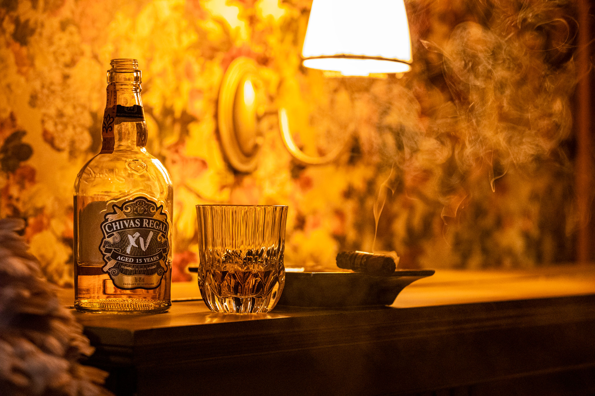 Reklamná fotografia whisky Chivas Regal XV s pohárom a cigarou vo whisky clube Bourbon Street v Nových Zámkoch
